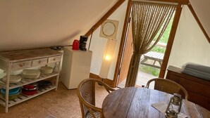 Una cocina acogedora con una mesa de madera, sillas y un refrigerador.