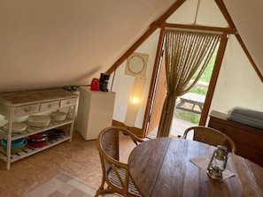 Eine gemütliche Küche mit einem Holztisch, Stühlen und einem Kühlschrank.