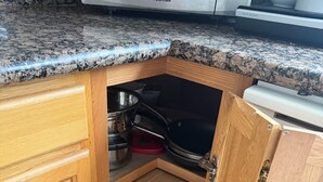 A kitchen with wooden cabinets, a granite countertop, and a built-in microwave. - LA JOLLA PRIVATE STUDIO (San Diego)