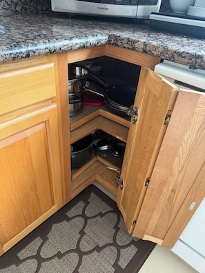 A kitchen with wooden cabinets, a granite countertop, and a built-in microwave. - LA JOLLA PRIVATE STUDIO (San Diego)