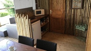 Une cuisine de taille réduite équipée d’un four à micro-ondes, d’un réfrigérateur et d’une porte en bois.