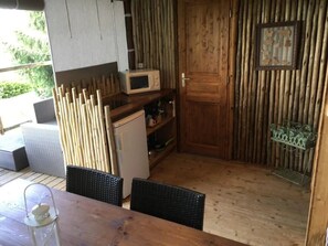 Eine kleine Küche mit einer Mikrowelle, einem Kühlschrank und einer Holztür.