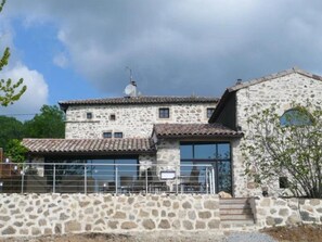 A stone building with a tiled roof, a balcony with metal railings, and a satellite dish. - Camping 3 étoiles - Piscine  - ccbgbcb (Plats)