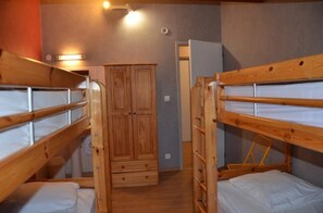 A bunk bed room with a wardrobe and a door in the background. - Camping 3 étoiles - Piscine  - ccbgcdg (Plats)