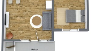 Eine 2-Zimmer-Wohnung mit Balkon, Küche, Wohnbereich und Bad.