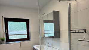 Ein modernes Badezimmer mit Toilette, Waschbecken und Dusche.