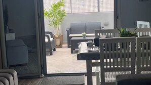 A modern living room with a sliding glass door leading to an outdoor patio area. - Perfect 1-bedroom apartment with AC in superb Giza Governorate (Giza Governorate)