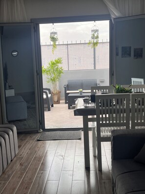Una sala de estar moderna con un ventanal corredero que da a un patio exterior.