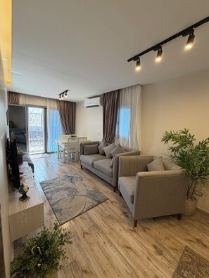Una sala moderna con un sofá, una mesita de centro y una planta en maceta.