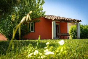 A house with a red exterior, a door, and a window. - Camping 3 étoiles - Piscine  - ccbgbde (Grospierres)