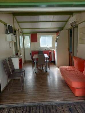 Ein gemütlicher Wohnraum mit Küchenzeile, Essbereich und einer Couch.