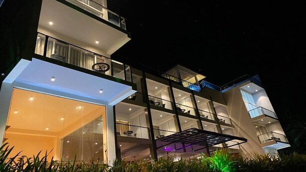 A multi-story modern building with balconies and large windows.