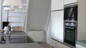 A modern kitchen with a central island, built-in appliances, and a skylight. - Modern, cozy vacation home with a fireplace, sauna, and large garden (Winsen (Aller))