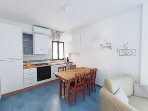 Une cuisine compacte avec un coin repas, un canapé et des éléments de décoration murale.