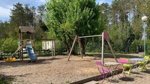 Un parque infantil con columpios, tobogán y estructura para escalar.