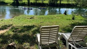 Vista del río con sillas y una masa de agua tranquila.
