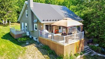 A two-story house with a covered porch and a fenced deck.
