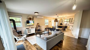 Ein großzügiger Wohnbereich mit Sofa, Esstisch und einer Küche im Hintergrund.
