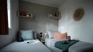 Una camera da letto con due letti, un comodino e mensole a parete.