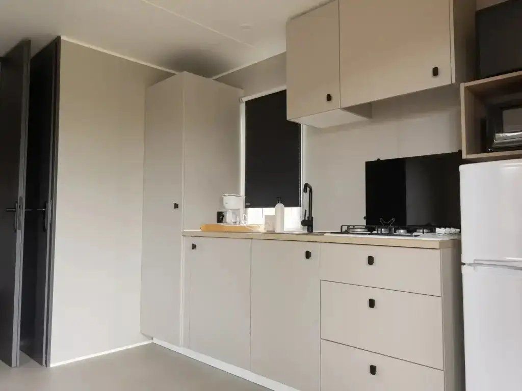 A modern kitchen with built-in cabinets, a countertop, and a refrigerator.