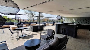 An outdoor patio with seating, a bar area, and a view of the cityscape. - 57 Spacious 2-bedroom, 2-bathroom Apartment (Johannesburg)