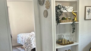 Une pièce comprenant un lit, une armoire blanche, un tapis à motifs et un tapis marron à poils longs.