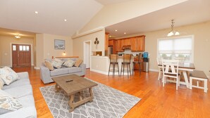 A spacious living room with a sofa, coffee table, and dining area with chairs and a table. - Gorgeous Views of Round lake (Round Lake)