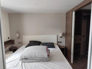 Ein Hotelzimmer mit einem Bett, zwei Nachttischen und einer Tür zu einem Schrank.