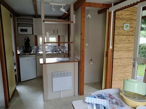 Eine kleine Küche mit integriertem Mikrowellenherd, einem Kühlschrank und einem Spülbecken.