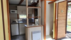 Eine kleine Küche mit Mikrowelle, Kaffeemaschine und kleinem Kühlschrank.