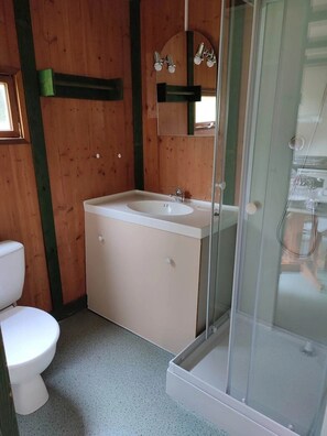 Et badeværelse med toilet, vask og bruser.