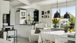 A bright, white interior with a kitchen, dining area, and a view of the outside. - House with cozy corners near Roskilde (Eskebjerg)