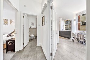 Ein modernes Interieur mit einer Diele, die zu einem Badezimmer, einem Essbereich und einer Küche führt.