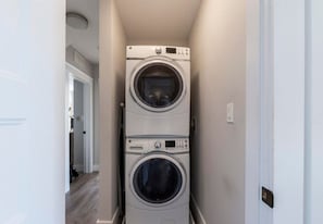 Un cuarto de lavandería con dos lavadoras apiladas.