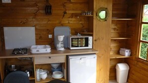 Una cocina compacta equipada con microondas, cafetera y refrigerador pequeño.