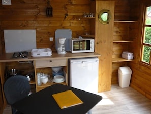 A compact kitchen with a microwave, coffee maker, and small refrigerator.