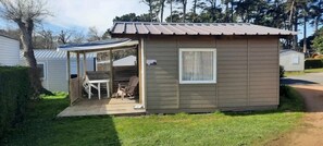 Une petite cabane à un seul étage, dotée d’un patio couvert, d’une fenêtre et d’une porte.