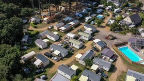 An aerial view of a mobile home park with compact housing units, a swimming pool, and a central road. - Camping 3 étoiles - Piscine  - ccbgcib (Perros-Guirec)