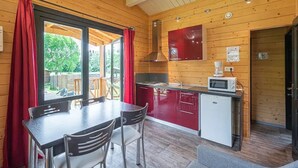 A compact kitchen with a dining area, a microwave, and a small refrigerator.