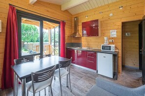 A compact kitchen with a dining area, a microwave, and a small refrigerator.