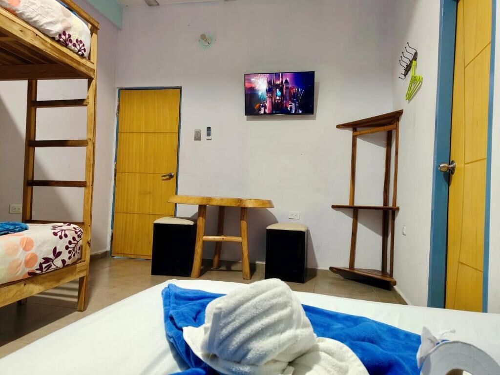 A room with bunk beds, a desk, speakers, and a TV.