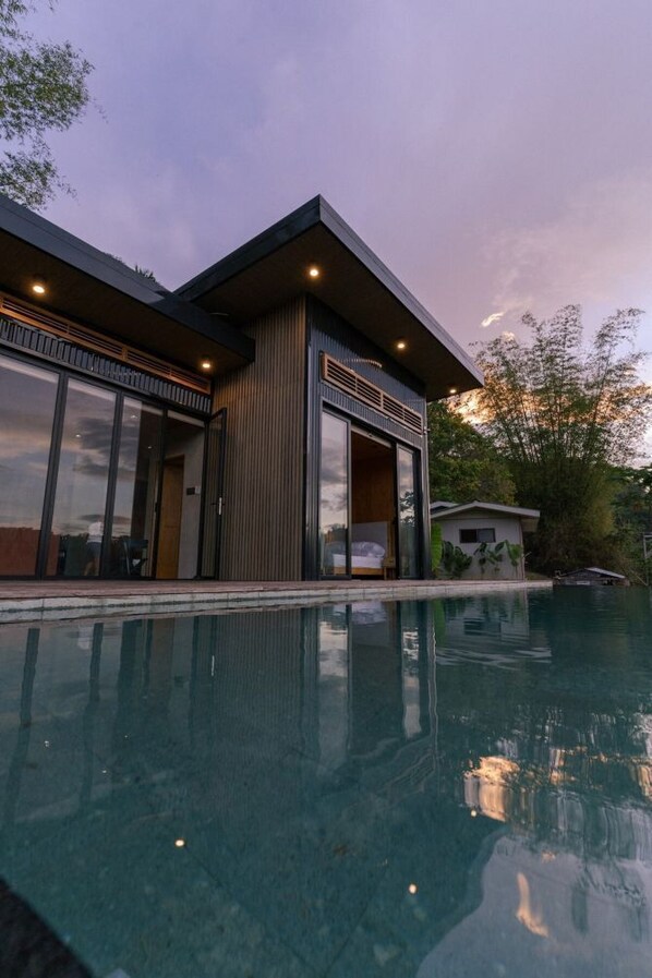 A modern house with a swimming pool, large glass doors, and a wooden exterior.