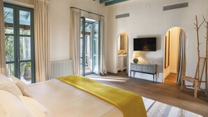 Una camera d'albergo con un letto, una televisione, una scrivania e una sedia.