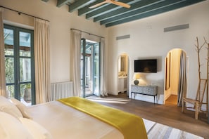 Ein Hotelzimmer mit Bett, Fernseher, Schreibtisch und Stuhl.