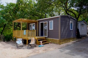 Eine kleine Holzhütte mit einer Terrasse, einer Veranda und einer Haustür.