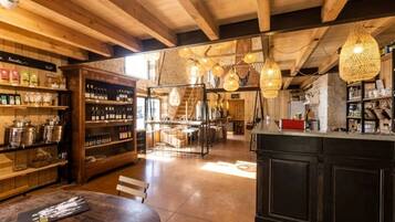 Un intérieur rustique avec des poutres en bois, un coin bar et des luminaires suspendus.