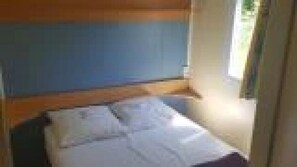 Ein kleines Zimmer mit Bett, Fenster und Tür.