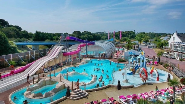 A water park with multiple slides, a large pool, and a covered area. - Camping 4 étoiles - Parc aquatique - ccbgde0 (La Baule)