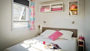 Una camera da letto con un letto, comodini, una finestra e mensole a parete.