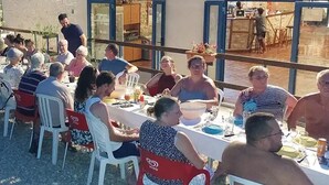 An outdoor dining area with tables and chairs, a building with large windows, and a view of the street. - Camping 3 étoiles - Piscine  - ccbfi0d (Mauroux)